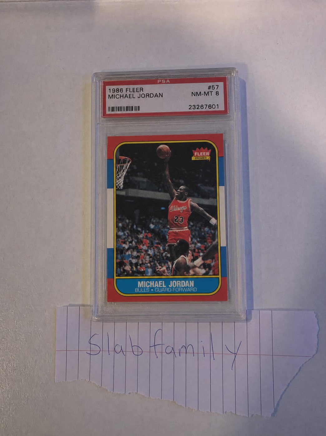 Intake photo: the PSA slab of Michael Jordan — Rookie beside a handwritten "slab family" note